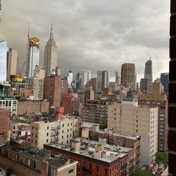 Modern buildings in city against cloudy sky