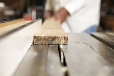 Midsection of carpenter working in workshop