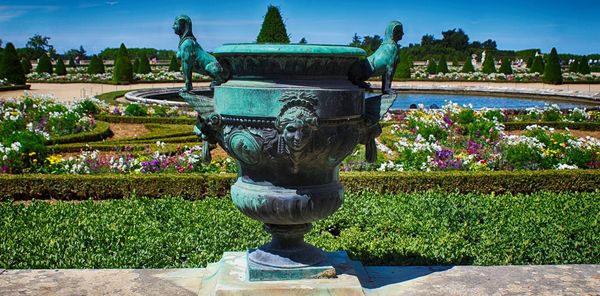 Close-up of statue in park against blue sky