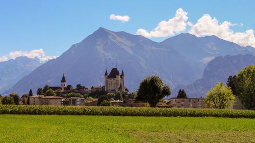 Scenic view with castle in front of mountains against sky