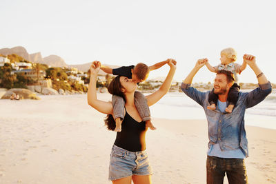 Full length of friends standing on beach