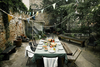 Food and drink set up on dining table in decorated back yard