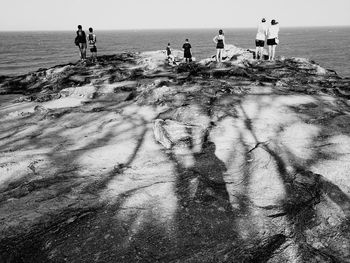 People on beach by sea against sky