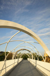 Footbridge over footpath against sky