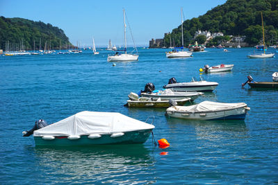 Boats moored in sea against clear sky