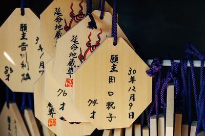 Close-up of text hanging on wood in row