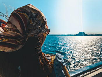 Rear view of woman in boat against sea