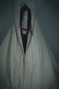 Close-up of woman with spooky make-up wrapped in blanket