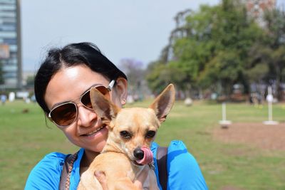 Portrait of woman with chihuahua at park