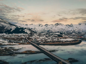 Aerial view of snowcapped mountains against sky during sunset