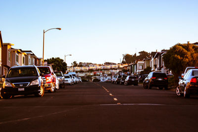 Cars on city street against clear sky