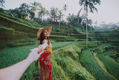 Young woman holding hand at rice terrace