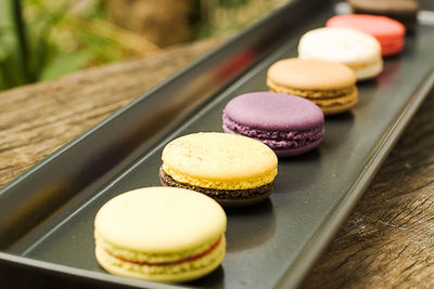 Colorful and delicious french macaron cookies varieties on a wooden table