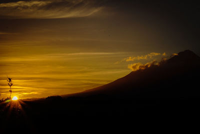 Scenic view of silhouette mountains against sky at sunset