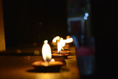 Close-up of lit candles on table