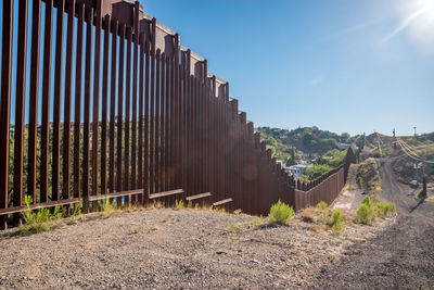 Metallic railing at roadside against clear sky