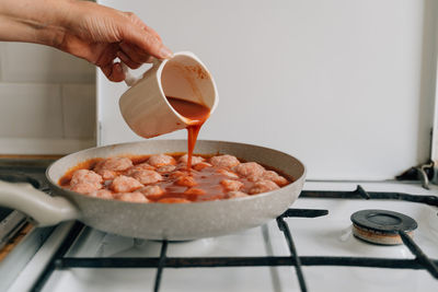 Cropped hand of person preparing food on table