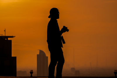 Silhouette man standing against sky during sunset 