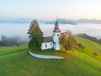 Aerial drone shot of sveti tomaž church in Škofja loka in slovenia on a misty morning