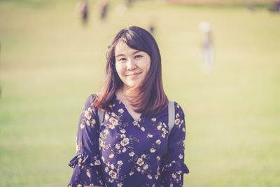 Portrait of smiling woman standing on field