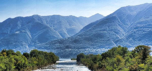 Scenic view of river amidst mountains against sky