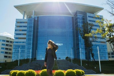 Woman standing by modern office building