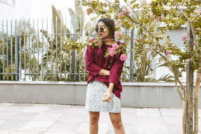 Young woman standing on sidewalk