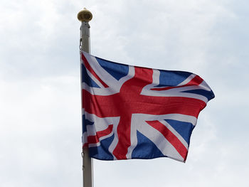 Low angle view of flag against blue sky