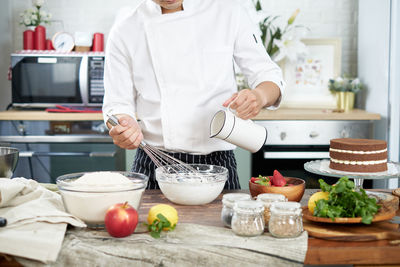 Midsection of man having food in kitchen