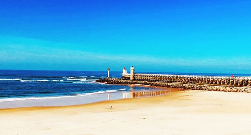 Scenic view of beach against blue sky