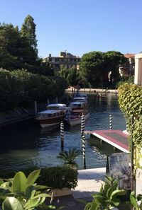 Sailboats moored on lake against buildings