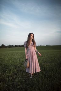 Woman standing on field against sky