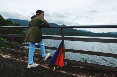Rear view of man standing on railing