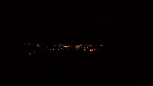 Illuminated cityscape against sky at night