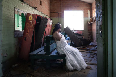 Woman sitting on window at home