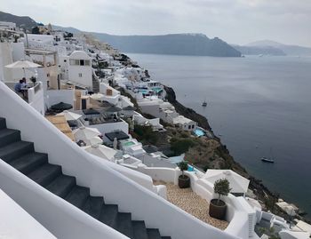 High angle view of townscape by sea against sky