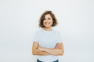 Portrait of a smiling young woman against white background