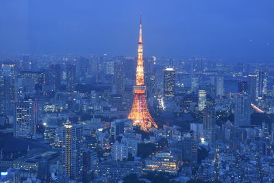 Illuminated buildings in city against sky