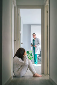 Doctor looking at depressed woman at hospital
