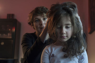 Mother massaging girl head at home