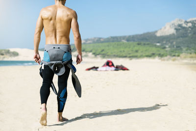 Full length of shirtless man on beach