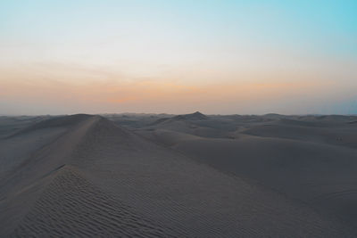 Scenic view of desert against sky during sunset