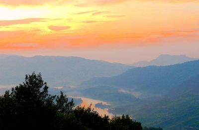 Scenic view of dramatic sky over forest during sunset