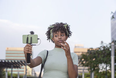 Young  woman walks around the city and broadcasts live on her smartphone.young blogger concept