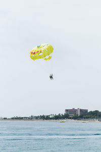 People paragliding over sea against clear sky