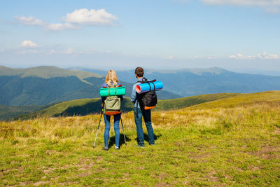 Boys standing on field against mountain range