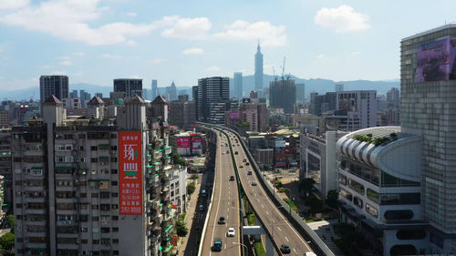 High angle view of street amidst buildings in city against sky