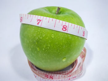 Close-up of green fruits against white background