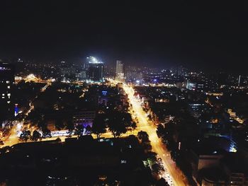 Illuminated cityscape against sky at night