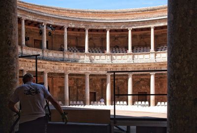 Rear view of man climbing up of historical building